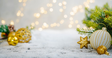 Wall Mural - christmas holiday background with snow, fir tree and decorations with christmas light behind. christ