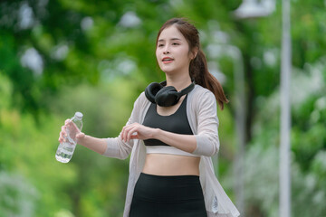 Smiling  Asian woman doing sport exercises running jogging in morning park, skinny fit in sports wear outfit leggings. fitness woman running around in the park.