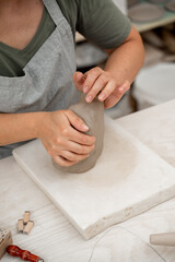 Wall Mural - Removing air bubbles from clay before modeling to avoid the ruination of a ceramic product. Wedging the clay before starting making a pottery project to create proper consistency.