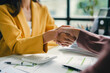 © amnaj - Businesswomen shaking hands after reaching an agreement on a deal during a meeting at the office