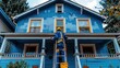 © Miodrag - Painter applying fresh blue paint to a charming house on a sunny day in a residential neighborhood