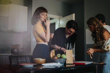 Poster - Group of friends enjoying a casual moment in the kitchen, preparing snacks and engaging in conversation. Warm atmosphere and a sense of camaraderie among young adults.