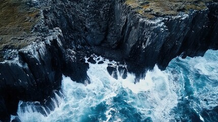 Waves crashing against rugged cliffs along a coastal shoreline during a stormy day in a scenic marine landscape