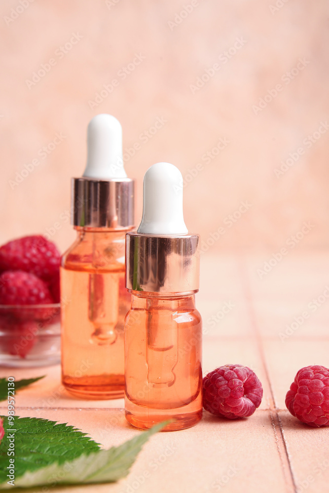 Bottles of cosmetic raspberry oil on pink tile table