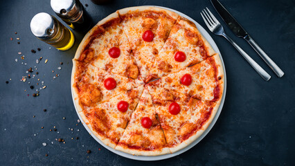 Italian food pizza with cheese, cherry tomatoes, and tomato sauce.