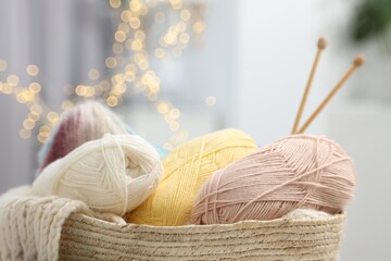 Poster - Skeins of yarn, knitting sample and needles in basket indoors, closeup