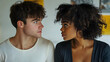© Prasanth - Young interracial couple is having a disagreement and looking at each other with concern
