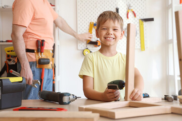 Poster - Happy father and his little son with different instruments assembling furniture at home