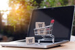 © Achira22 - Shopping online. cardboard box with a shopping cart logo in a trolley on laptop keyboard. Shopping service on The online web. offers home delivery