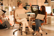 © Pixel-Shot - Female programmers with laptops giving each other high-five in office at night