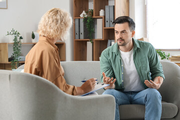 Wall Mural - Young man visiting psychologist in office