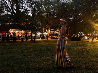 mother with daughter at carnival, food fest festival, food holiday, night carnival, woman in hat looking at city lights