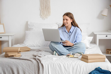 Poster - Happy female student with laptop and books studying at home