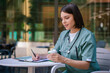 © zinkevych - Young pretty female doctor making notes and looking involved