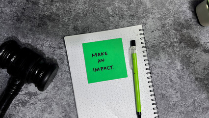 Wall Mural - Concept of Make an Impact write on sticky notes isolated on Wooden Table.