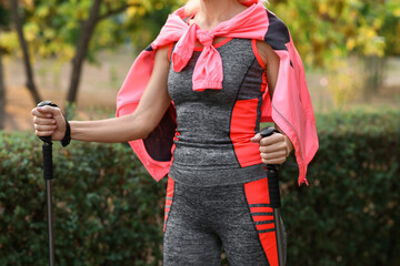 Poster - Beautiful mature woman training with walking poles in park, closeup