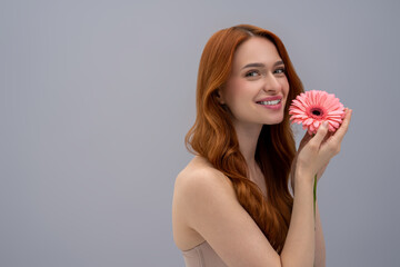 Long-haired beautiful young woman holding a flower and looking peaceful