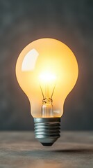 A glowing lightbulb held above a modern desk, symbolizing innovation and business growth, with soft light illuminating the workspace