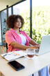 © Wavebreak Media - Working on laptop, plus size woman smiling with tea and smartphone on desk, at home