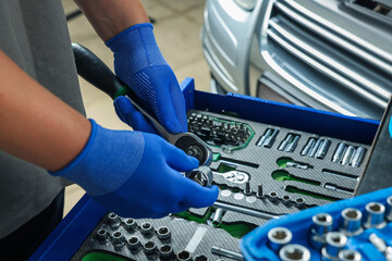 Wall Mural - Auto mechanic with different tools at automobile repair shop, closeup