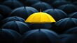 © Theeranan - A single yellow umbrella standing tall among many black umbrellas, symbolizing boldness and personal uniqueness
