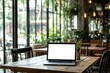© osagvsa - Bright café scene with a blank laptop on a wooden table