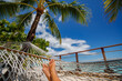 © Maridav - Beach travel holiday vacation woman feet selfie lying down relaxing on hammock outside sunbathing. Girl relaxing taking pov photo of her legs sun tanning in tropical summer destination