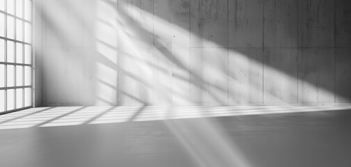 Aufkleber - A minimalistic interior space with light streaming through large windows, casting shadows on the concrete floor.