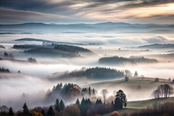 Poster - Misty landscape with rolling hills and forests at sunrise