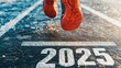 © Business Pics - Happy New Year 2025. A fresh start for 2025 depicted by a runner taking off from a starting line marked with '2025' on a straight