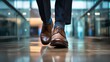© Ganesha88 - Feet of a businessman rushing in office corridor or open space because he is late to a meeting , man wearing brown suit show walking in modern office building