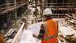 © AlfaSmart - Construction Worker Reviewing Building Plans at a Construction Site
