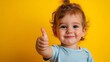 © Asim-Backgrounds - joyful toddler giving a thumbs up on a vibrant yellow background