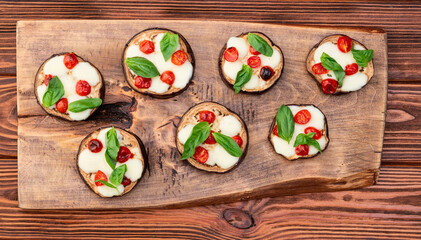 Canvas Print - Italian mini pizza . Aubergine (eggplant ) with mozzarella cheese and basil . On rustic background