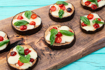 Italian mini pizza . Aubergine (eggplant ) with mozzarella cheese and basil . On rustic background