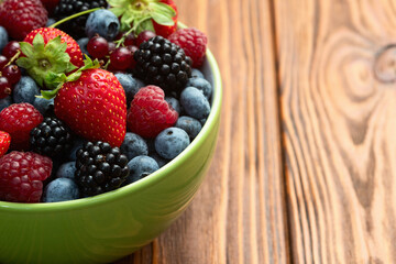 Wall Mural - Mix of ripe colorful berries in bowl photography . Blueberry , strawberry , raspberry , blackberry and red currant . Top view