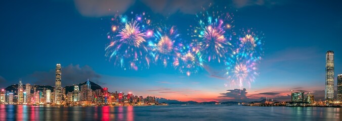Poster - A vibrant cityscape with skyscrapers illuminated at night, showcasing a spectacular fireworks display above a calm harbor.