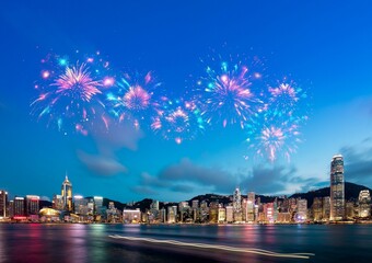 Wall Mural - Nighttime fireworks display over a cityscape.