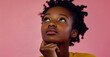 © Azazul - A young Black woman, deep in thought with her hand on her chin, gazes upward against a pink backdrop.