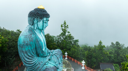 Great Buddha of Kamakura Daibutsu at Thai Temple - Wat Phra That Doi Phra Chan Mae Tha, Lampang province Thailand, Landmark and religious attractions in the riany season, aerial view