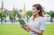 © TimeStopper - The group of South Asian tourists holding a map and searching for directions, with the iconic Wat Phra Kaew temple in the background in Bangkok, Thailand, enjoying their holiday adventure.