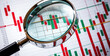 © budi - A magnifying glass focused on a stock market chart, symbolizing data analysis and investment decisions.
