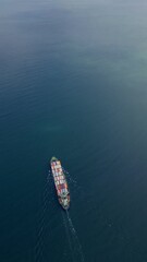 Wall Mural - A container ship sails across the calm blue waters