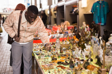 Wall Mural - Man chooses antiques at a flea market