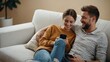 © Abubakar - Sofa, couple and relax with smartphone for joke, conversation and bonding together with connection. Happy people, man and woman with cellphone for mobile app, social media and online meme at home