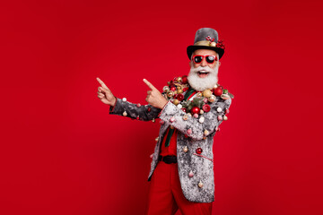 Photo of nice aged elegant man point empty space wear christmas tree balls costume sunglasses isolated red color background