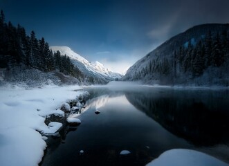 Poster - A calm lake in the mountains with a reflection of the snow-covered peaks and a cloudy sky.