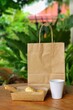© Kotchakorn - Close up at paper packaging including shopping bag,glass with blurred green forest background.Using Paper container for takeaway food or things can reduce plastic bag.Ecological,reusable concept.