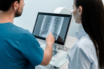 Doctor shows results to female patient x-ray of the lungs, smoking cigarettes problem. Doctor explaining lungs x-ray on Tablet PC screen to young patient. Doctor showing female patient x-ray shot