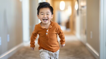 A young boy is running down a hallway with a big smile on his face